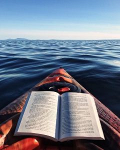 O carte într-o barcă, plutind pe mare